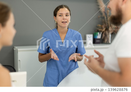 female administrator communicates with clients of a dental clinic female administrator communicates with clients of a dental clinic 139628876
