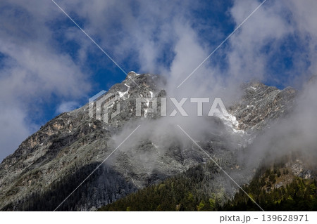 Dramatic Alpine Mountain Peaks with Low Clouds and Late Spring Snow 139628971