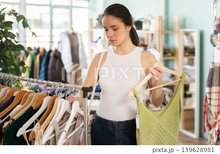 Young woman chooses dresses and tops in store 139628981