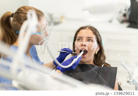 Woman dentist drilling and treating teeth of woman in clinic 139629011