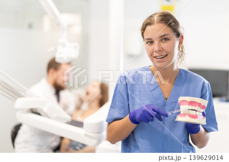 Portrait of a female dentist holding prosthetic jaw Portrait of a female dentist holding prosthetic jaw 139629014