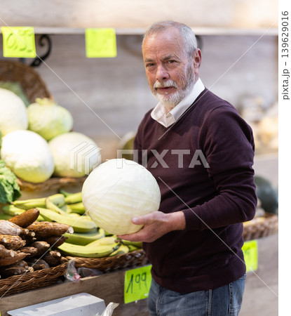 Mature male customer buying fresh cabbage in grocery store with assortment Mature male customer buying fresh cabbage in grocery store with assortment 139629016