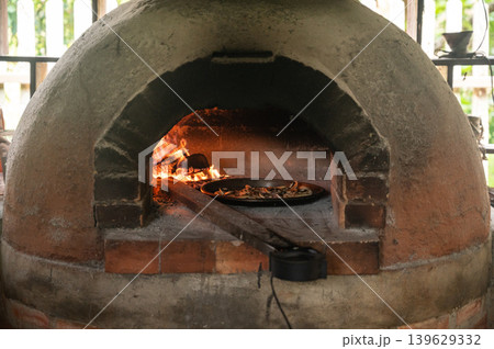 A pizza baking in wood fired oven. It can also be used to dry and smoke food. Cooking on a wood fire is authentic and brings an unrivalled flavour to your dishes. A pizza baking in wood fired oven. It can also be used to dry and smoke food. Cooking on a wood fire is authentic and brings an unrivalled flavour to your dishes. 139629332