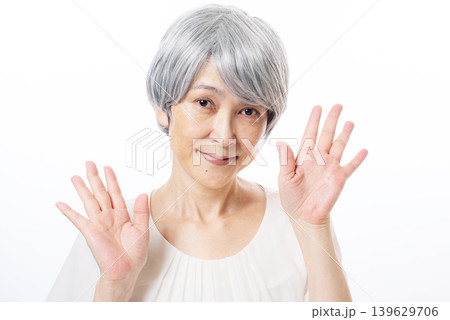 両手を広げておどけるシニア女性 139629706