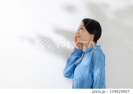 木漏れ日の中に立つ女性 139629807