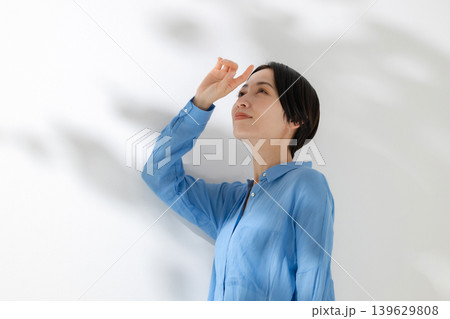 木漏れ日の中に立つ女性 139629808