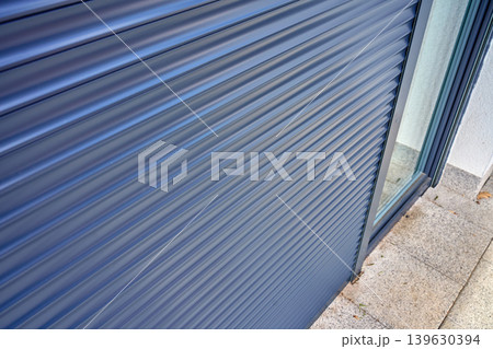 Closed roller shutter on glass door outside modern home Closed roller shutter on glass door outside modern home 139630394