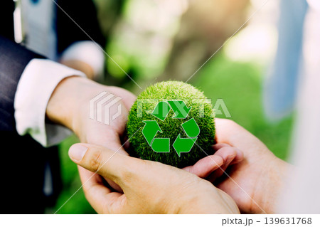 People hold green globes, a symbol of recycling, against a green spring backdrop. A concept for Earth Day. 139631768