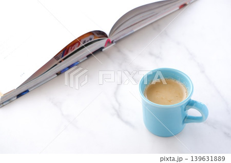 ページを開いた本(洋書)とコーヒーの入ったコーヒーカップで、コーヒーを飲みながら読書を楽しむイメージ ページを開いた本(洋書)とコーヒーの入ったコーヒーカップで、コーヒーを飲みながら読書を楽しむイメージ 139631889