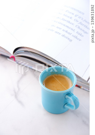 ページを開いた本(洋書)とコーヒーの入ったコーヒーカップで、コーヒーを飲みながら読書を楽しむイメージ ページを開いた本(洋書)とコーヒーの入ったコーヒーカップで、コーヒーを飲みながら読書を楽しむイメージ 139631892