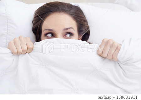 Morning, scared woman in bed and under cover, wake up and relax getting ready hiding from new day. Blanket, face and girl in bedroom with rest, wellness and comfort in hotel room, home or apartment. Morning, scared woman in bed and under cover, wake up and relax getting ready hiding from new day. Blanket, face and girl in bedroom with rest, wellness and comfort in hotel room, home or apartment. 139631911