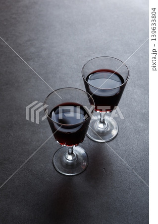 赤ワインで乾杯 - 赤ワインが注がれたふたつのワイングラスで、乾杯をしているイメージ 139633804