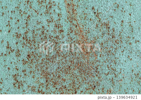 Rusty Turquoise Metal Texture. Close-up texture of weathered turquoise painted metal surface with scattered brown rust spots and oxidation patterns. 139634921