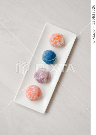 Top View of Four Colorful Mochi Balls Arranged on White Plate 139635326