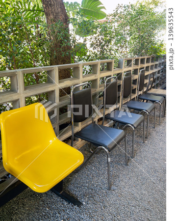 Outdoor Waiting Chairs with Yellow Seat in Garden Setting. 139635543