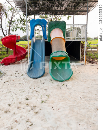 Colorful Outdoor Playground Slides on Sand for Kids Recreation Colorful Outdoor Playground Slides on Sand for Kids Recreation 139635550
