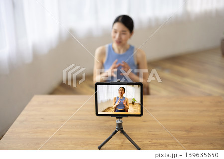 タブレットの前で話すヨガウェアを着た日本人のミドル女性 タブレットの前で話すヨガウェアを着た日本人のミドル女性 139635650