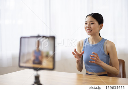 タブレットの前で話すヨガウェアを着た日本人のミドル女性 タブレットの前で話すヨガウェアを着た日本人のミドル女性 139635653