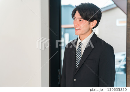 マイホームに帰宅するスーツ姿の笑顔の若いアジア人男性 マイホームに帰宅するスーツ姿の笑顔の若いアジア人男性 139635820