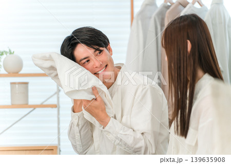 リビングで洗濯物を畳む笑顔の夫婦,カップル 139635908