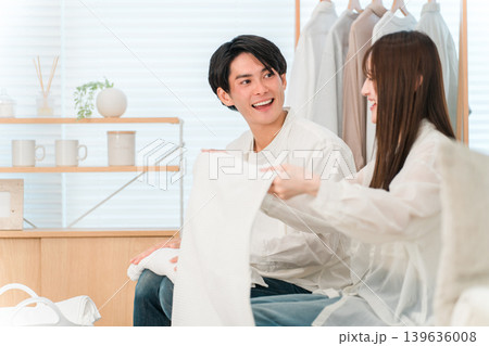 リビングで洗濯物を畳む笑顔の夫婦,カップル（家事参加,家事分担） 139636008