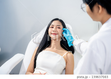Asian woman consulting with a doctor at a modern aesthetic clinic for facial treatment. 139637083
