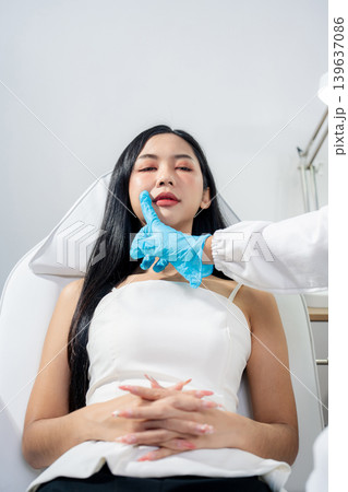 Asian woman consulting with a doctor at a modern aesthetic clinic for facial treatment. 139637086