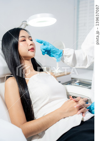 Asian woman consulting with a doctor at a modern aesthetic clinic for facial treatment. Asian woman consulting with a doctor at a modern aesthetic clinic for facial treatment. 139637087