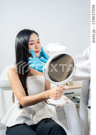 Asian woman consulting with a doctor at a modern aesthetic clinic for facial treatment. Asian woman consulting with a doctor at a modern aesthetic clinic for facial treatment. 139637098