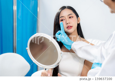 Asian woman consulting with a doctor at a modern aesthetic clinic for facial treatment. 139637100