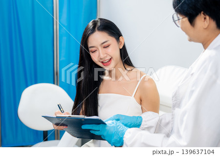 Asian woman consulting with a doctor at a modern aesthetic clinic for facial treatment. Asian woman consulting with a doctor at a modern aesthetic clinic for facial treatment. 139637104