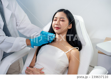 Asian woman consulting with a doctor at a modern aesthetic clinic for facial treatment. Asian woman consulting with a doctor at a modern aesthetic clinic for facial treatment. 139637110