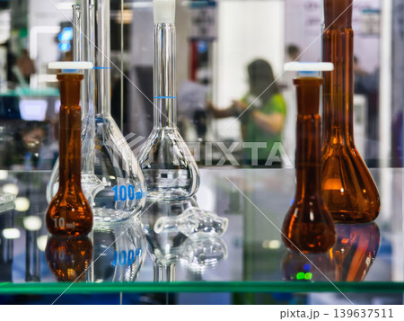 Glass laboratory equipment on display at a science exhibition with visitors in the background at a convention center Glass laboratory equipment on display at a science exhibition with visitors in the background at a convention center 139637511
