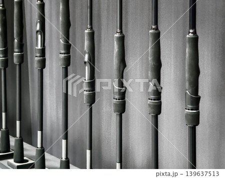 Fishing rods are displayed neatly on a wall in a store showing various models and sizes for fishing enthusiasts 139637513