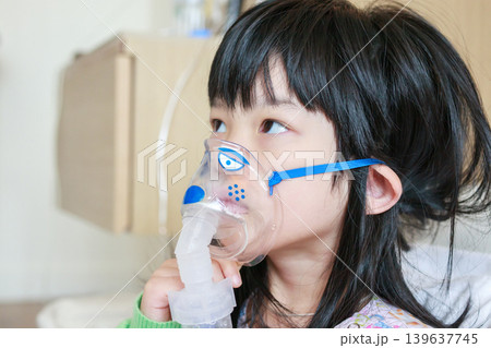 Sick little asian girl inhalation with nebulizer for respiratory treatment Sick little asian girl inhalation with nebulizer for respiratory treatment 139637745