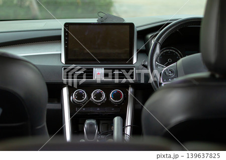 Modern car interior with touchscreen dashboard, steering wheel and climate control system showcasing contemporary automotive technology and transportation design. Modern car interior with touchscreen dashboard, steering wheel and climate control system showcasing contemporary automotive technology and transportation design. 139637825