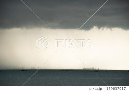 Storm cloud rain curtain sea horizon dark sky heavy rain seascape distant ship rough weather atmospheric scene gray cloud Storm cloud rain curtain sea horizon dark sky heavy rain seascape distant ship rough weather atmospheric scene gray cloud 139637917