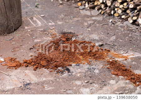 A pile of raw red iron ore soil sits on the ground surface, representing natural earth composition, geological mining resources, industrial mineral extraction, and environmental backgrounds A pile of raw red iron ore soil sits on the ground surface, representing natural earth composition, geological mining resources, industrial mineral extraction, and environmental backgrounds 139638050
