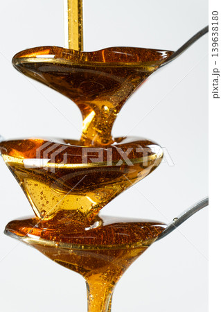 Abstract art of maple syrup flowing over spoons Abstract art of maple syrup flowing over spoons 139638180