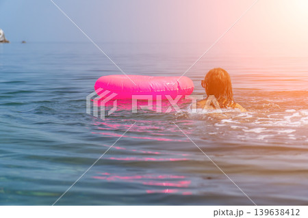 Swimming ocean vacation woman with pink inflatable ring floating peacefully under sunny summer sky 139638412