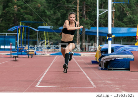 Beautiful female athlete triple jump Beautiful female athlete triple jump 139638625