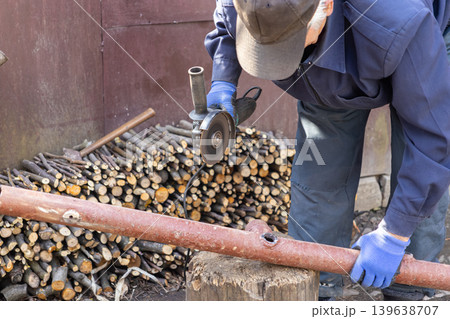 Skilled craftsman using an angle grinder to cut a metal pipe outdoors, representing home improvement projects, manual labor, construction repair, and professional maintenance work Skilled craftsman using an angle grinder to cut a metal pipe outdoors, representing home improvement projects, manual labor, construction repair, and professional maintenance work 139638707