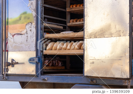 A delivery truck is loaded with fresh bread loaves on wooden shelves, representing efficient bakery logistics, local food distribution, small business supply chains, and morning commerce A delivery truck is loaded with fresh bread loaves on wooden shelves, representing efficient bakery logistics, local food distribution, small business supply chains, and morning commerce 139639109