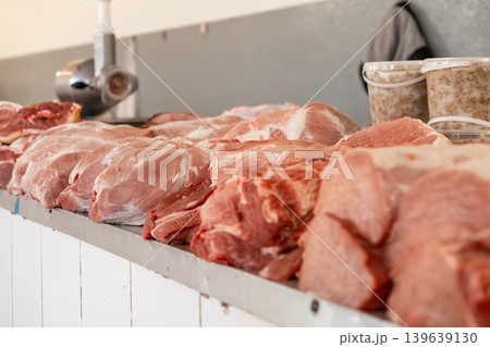 Fresh raw pork meat cuts are displayed on a stainless steel counter in a professional butcher shop, showcasing organic quality and culinary preparation for retail and gastronomy business use Fresh raw pork meat cuts are displayed on a stainless steel counter in a professional butcher shop, showcasing organic quality and culinary preparation for retail and gastronomy business use 139639130