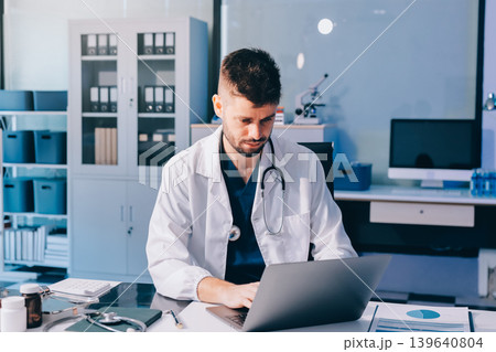 Man, doctor and laptop typing in healthcare research, communication or social media at office desk. Male medical expert working on computer in online search, browsing or chatting on tablet at clinic 139640804