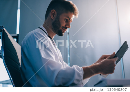 Man, doctor and laptop typing in healthcare research, communication or social media at office desk. Male medical expert working on computer in online search, browsing or chatting on tablet at clinic 139640807