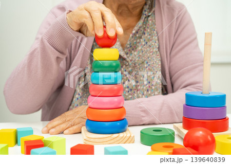 Alzheimer disease AD, Asian elderly woman patient suffering from dementia learn practical motor skills rehabilitation. 139640839