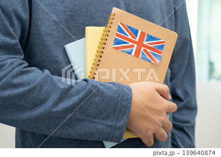 Learn English language, Asian teenage student hold book with flag in course at school. 139640874