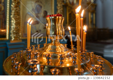 Golden Orthodox Church Candles and Icon on Altar With Lit Flames and Warm Reflection Golden Orthodox Church Candles and Icon on Altar With Lit Flames and Warm Reflection 139642152