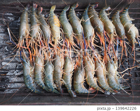 Shrimp seafood grill raw fresh prawn barbecue cooking arranged on metal grate with natural color texture preparing meal outdoor 139642226